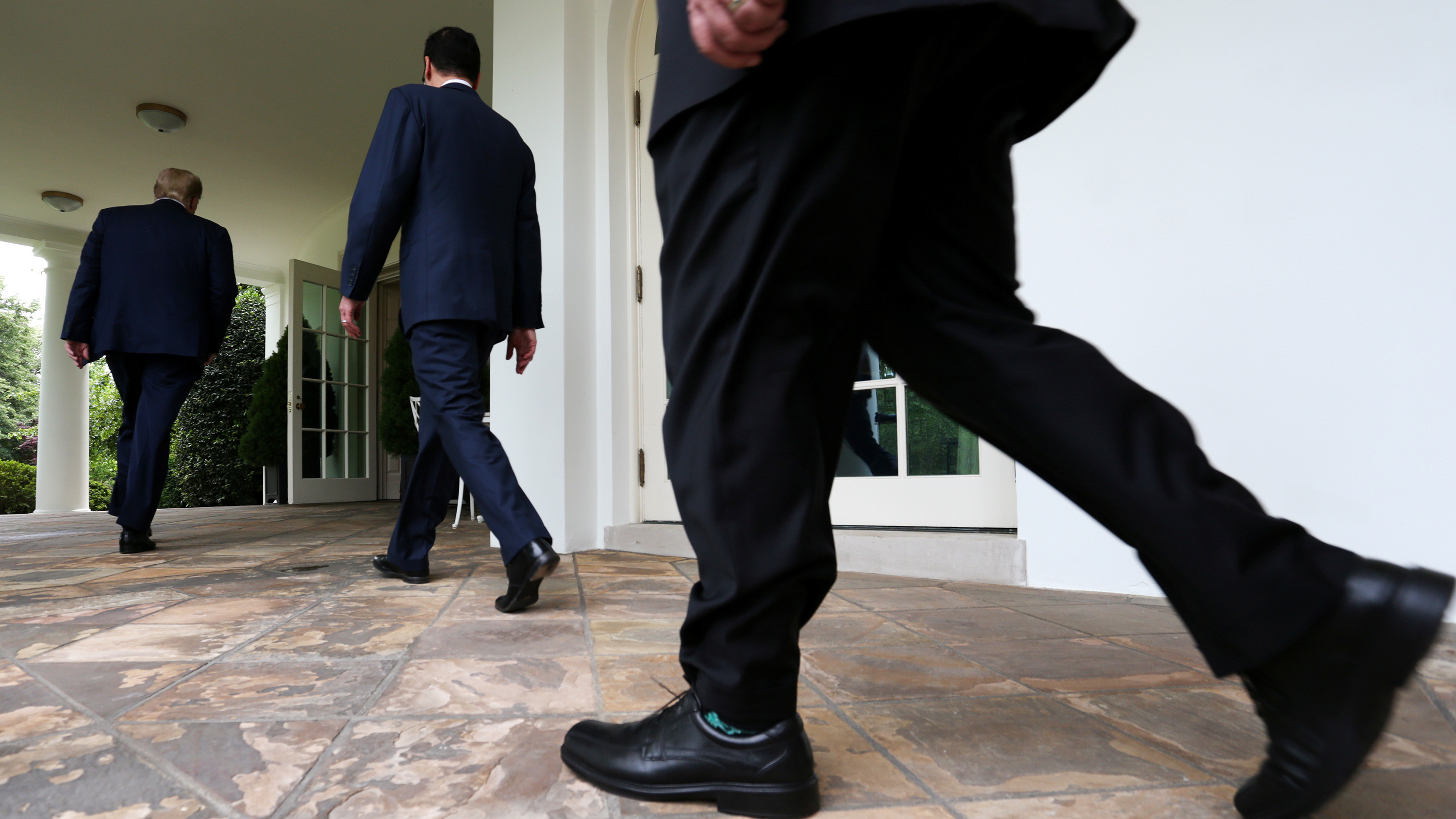 The photo shows the lower portion of the president walking past the camera with Treasury Secretary Steven Mnuchin and Secretary of State Mike Pompeo slightly ahead.