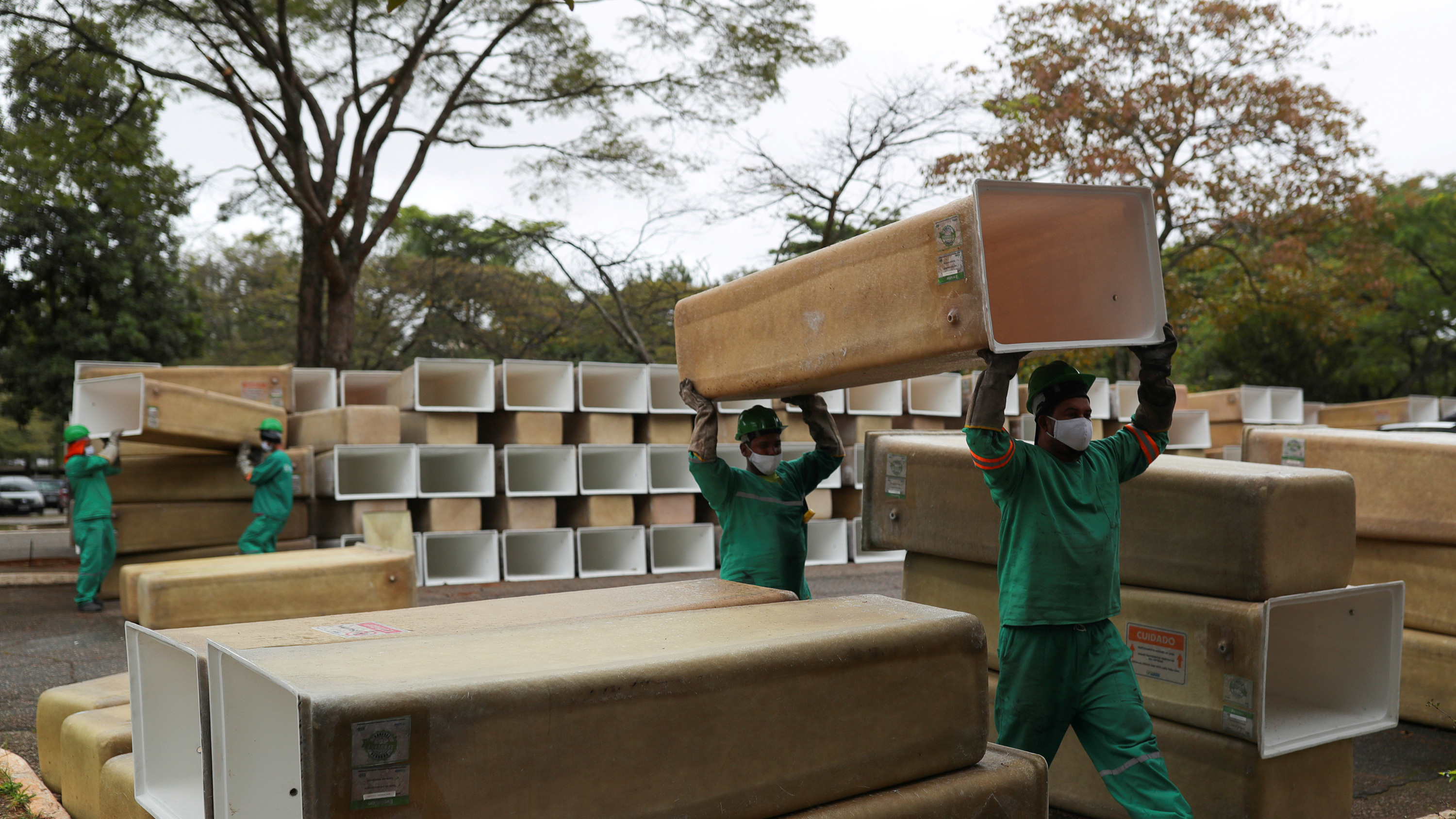 The image shows several workers amid a huge stack of boxes.