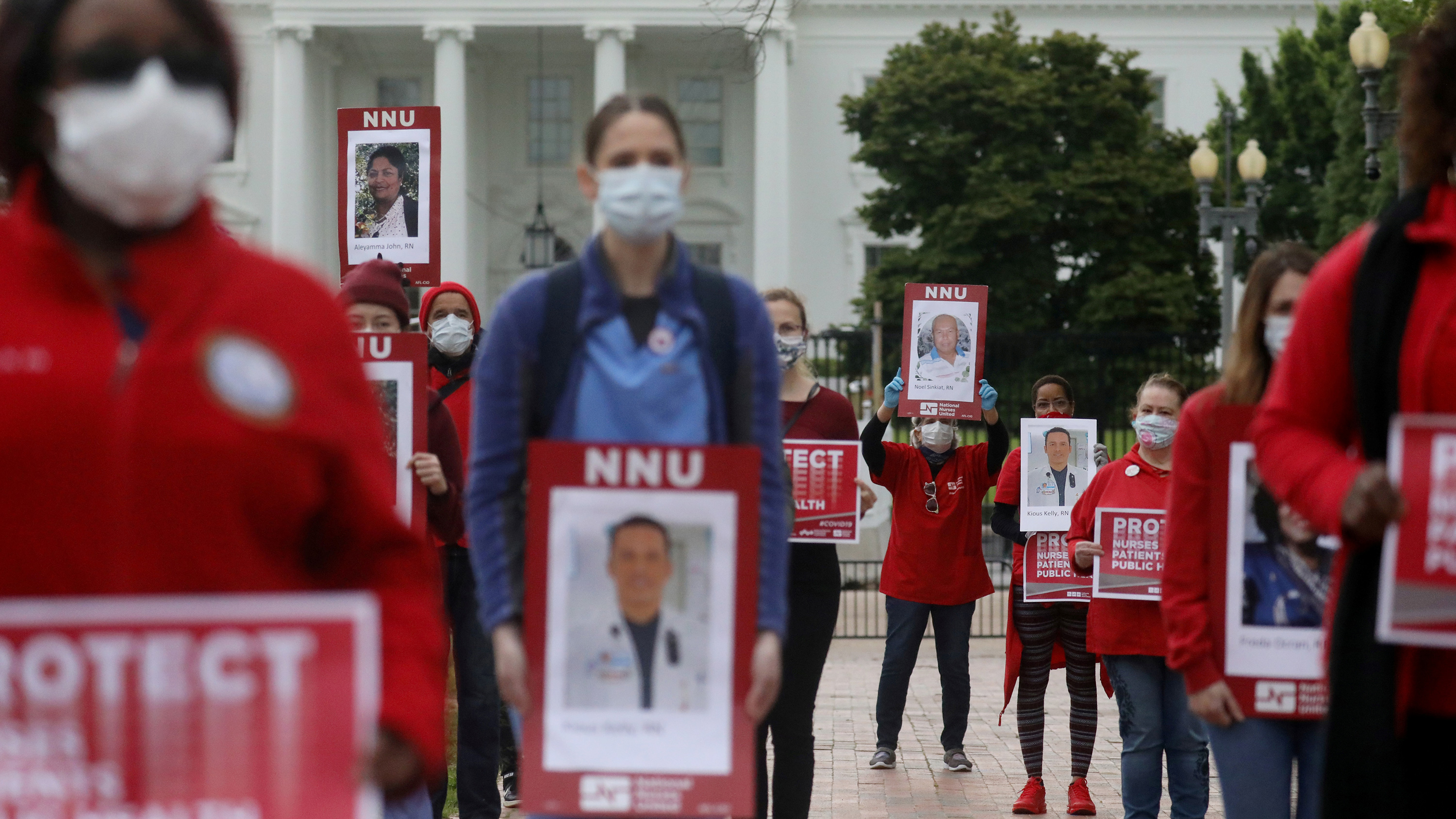 The picture shows a crods of protesting nurses holding signs.