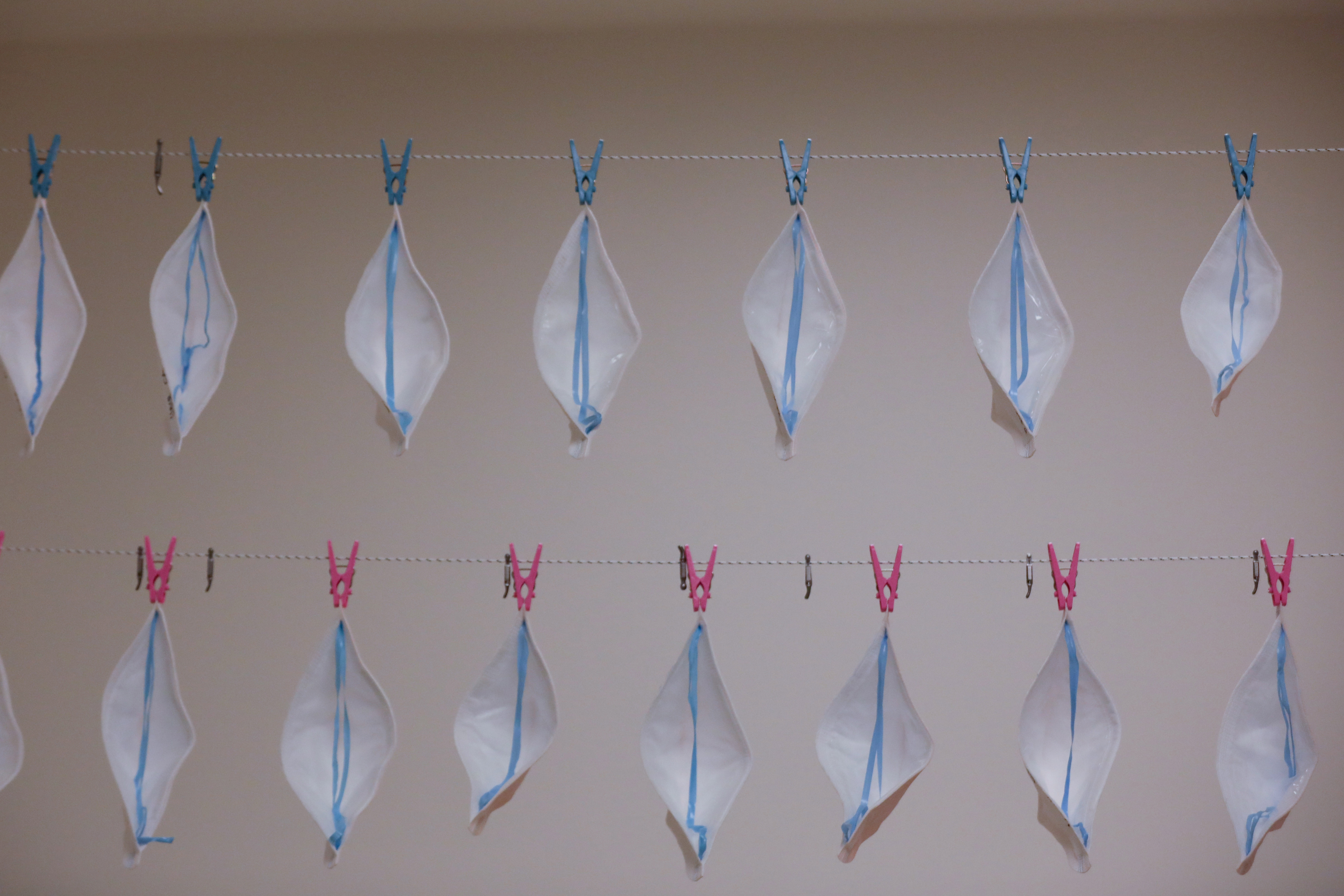 Picture shows two rows of protective masks tacked to a wall.