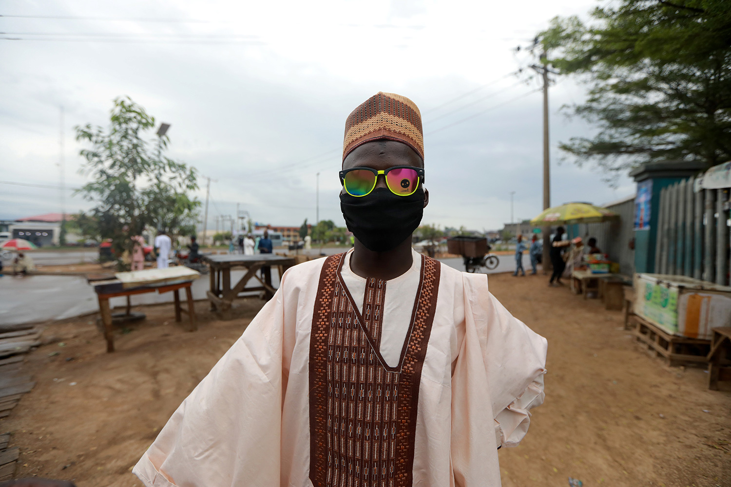 This is a striking image with a man whose face is covered by a mask as well as colorful sunglasses.
