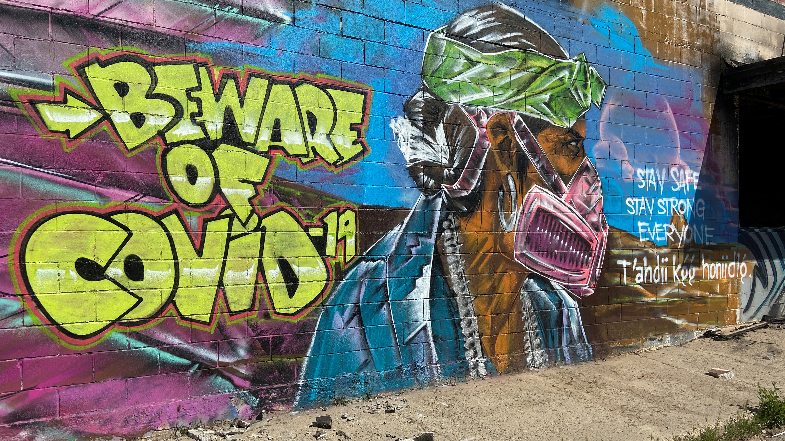 Picture shows an amazing mural of a man wearing a mask painted on the side of a wall.