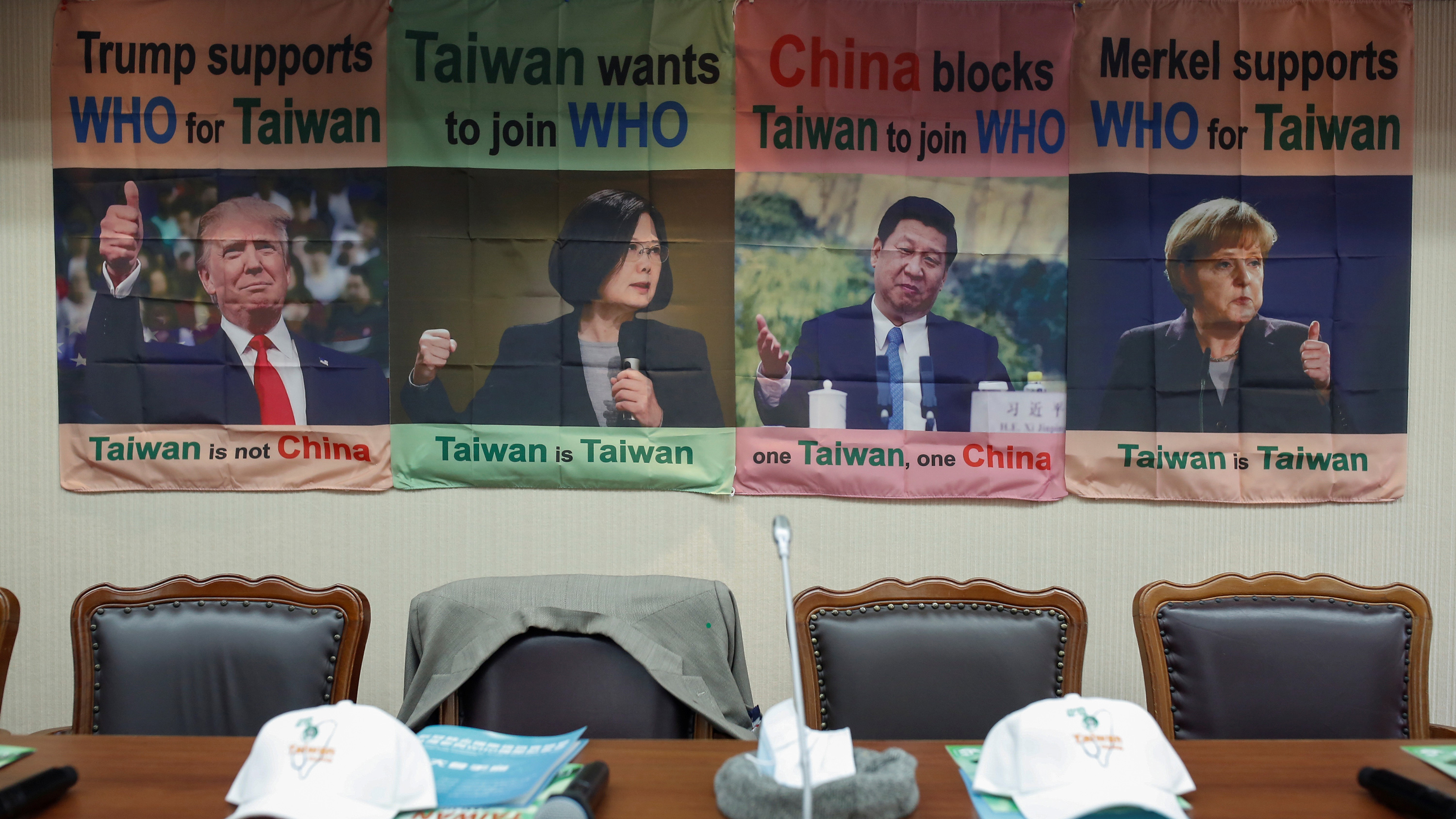 The photo shows empty seats, one with a jacket thrown over the back of it, with posters in the background showing testimonials by world leaders in support of Taiwan's WHO bid.