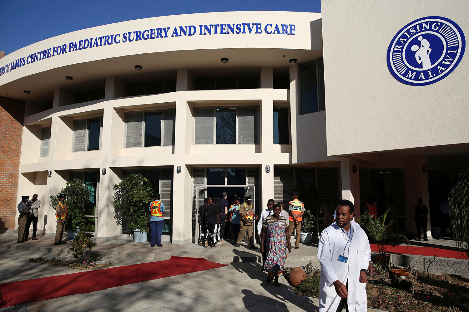 The photo shows the hospital entrance on a brilliant blue sky day.