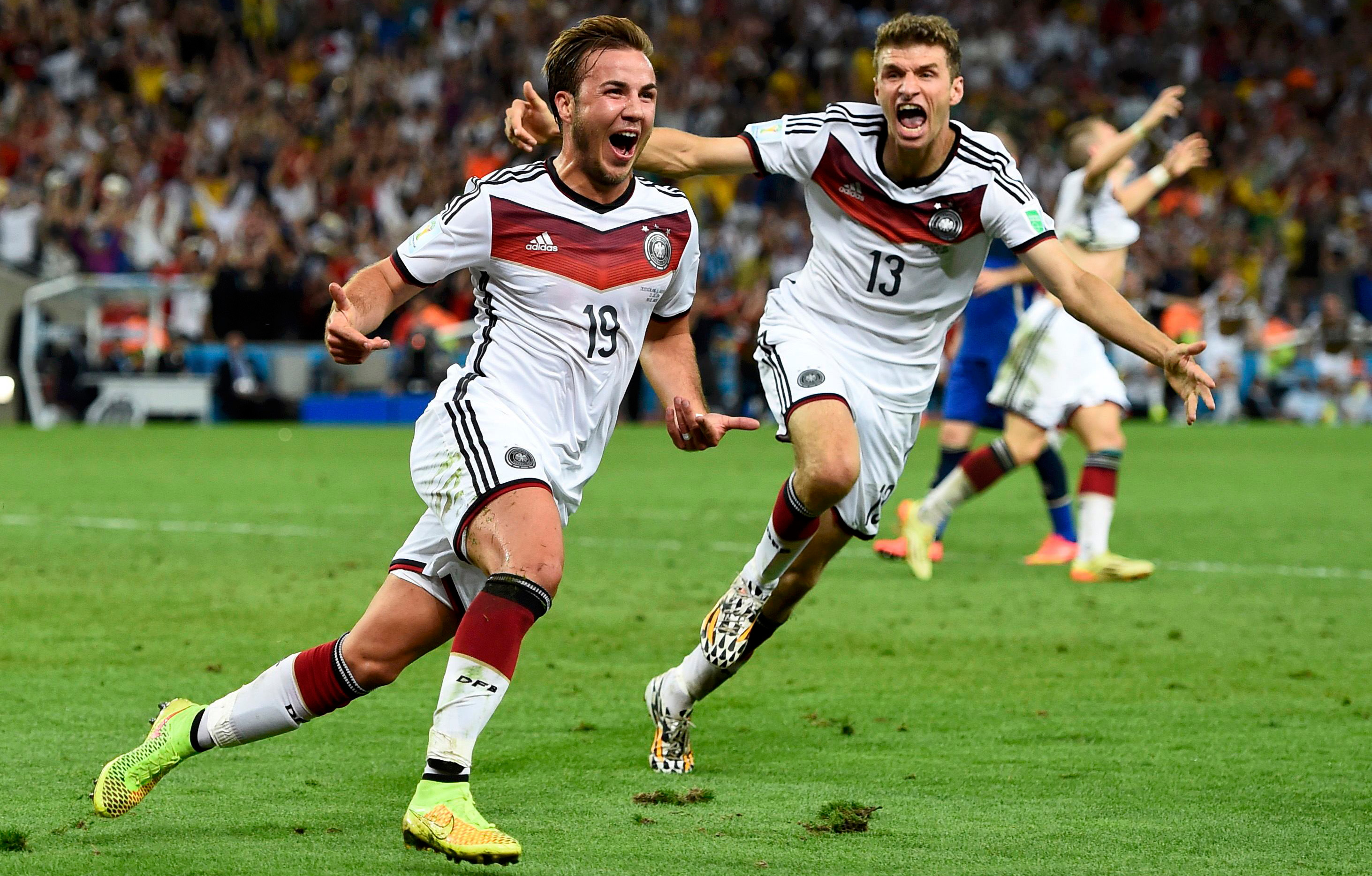 The photo shows two German players running in celebration.