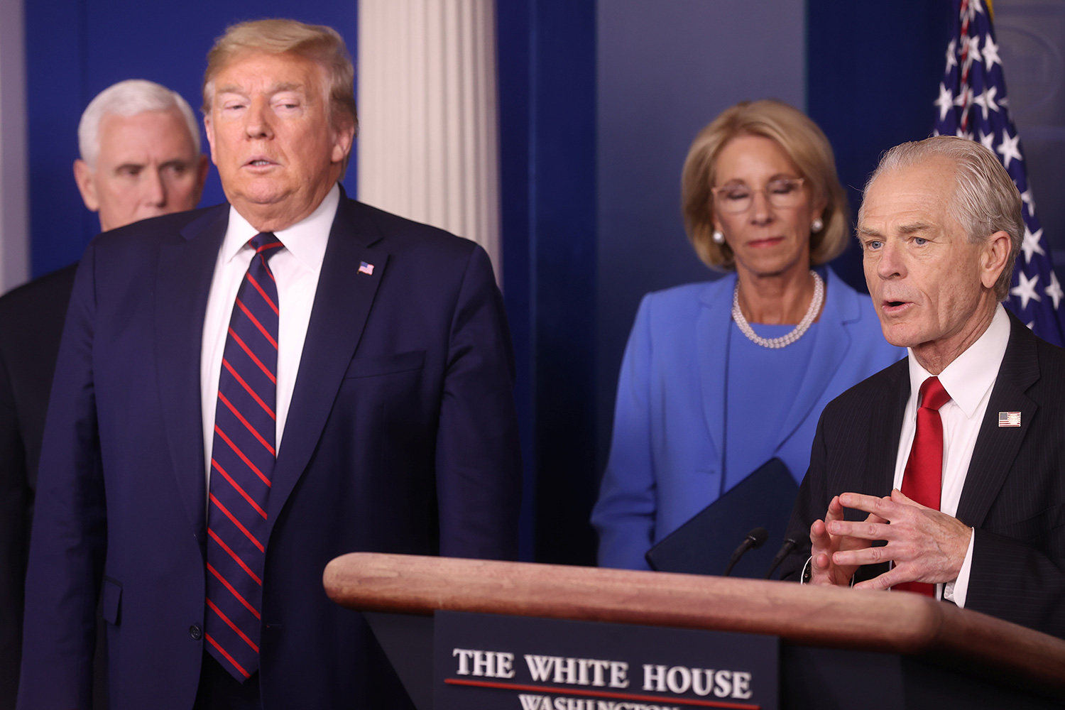 The photo shows several officials gathered around a podium during a press conference.