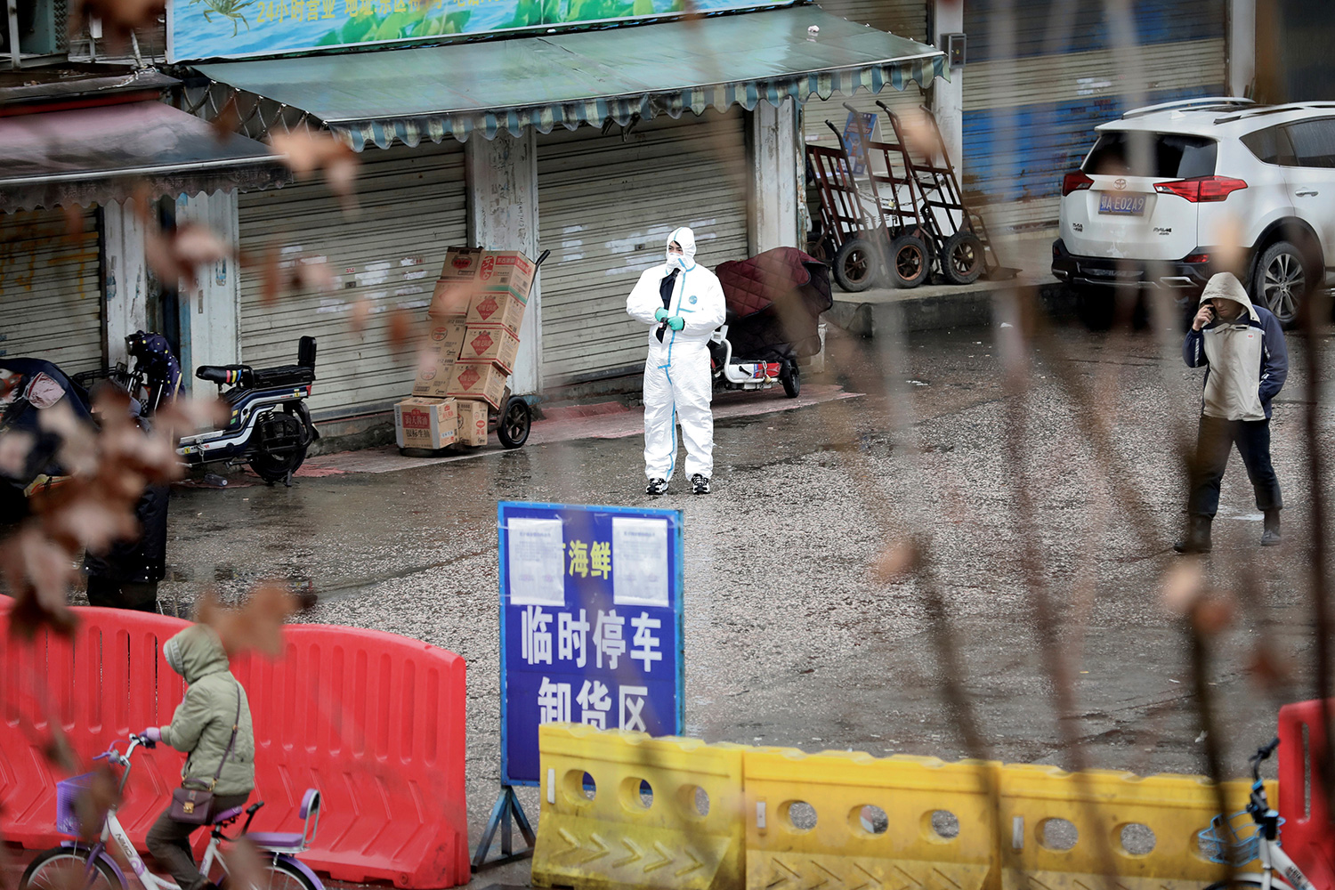 Picture shows a street with a health worker in front of the shuttered market.