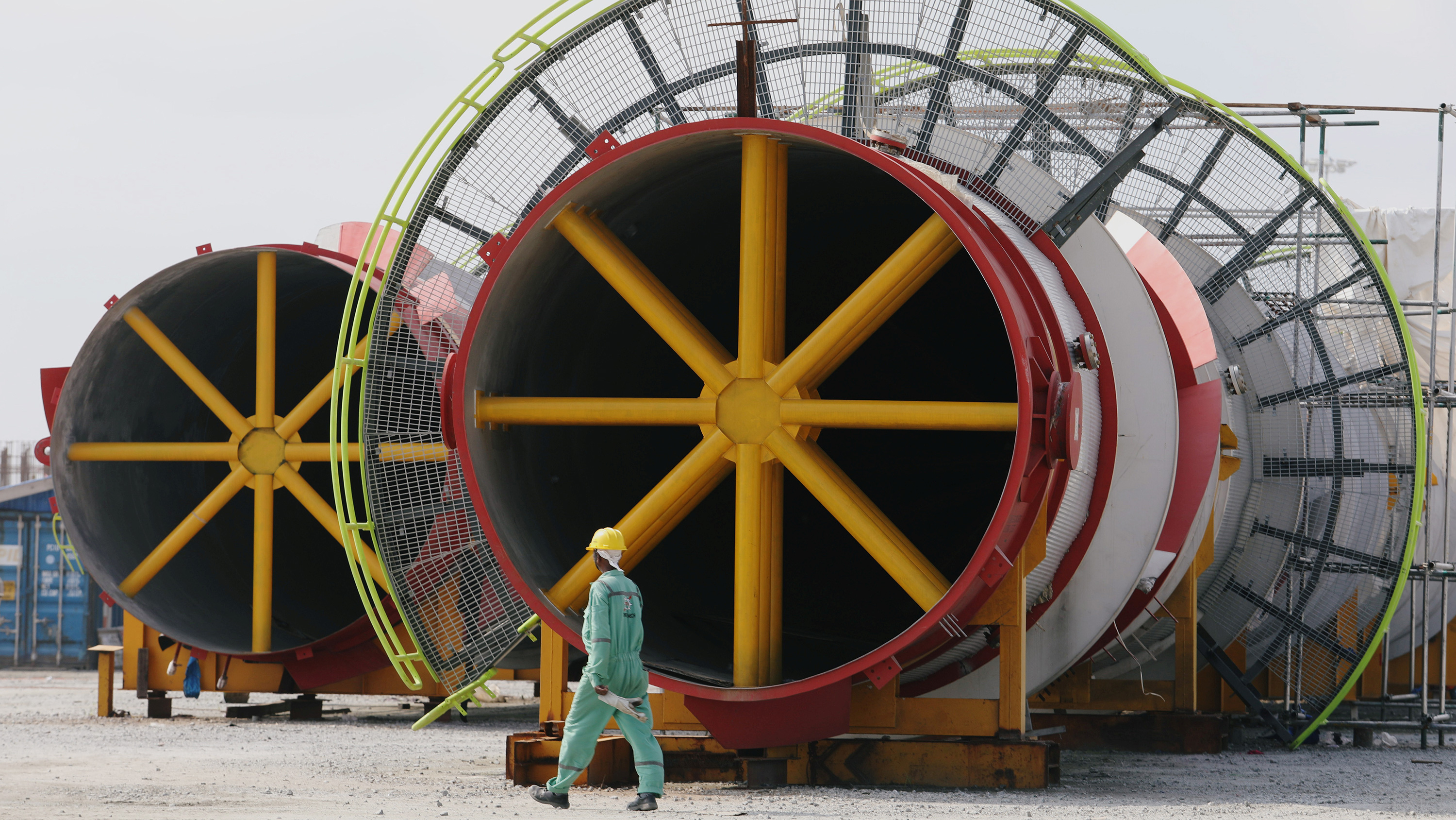 Picture shows a worker working past large metal spindles.