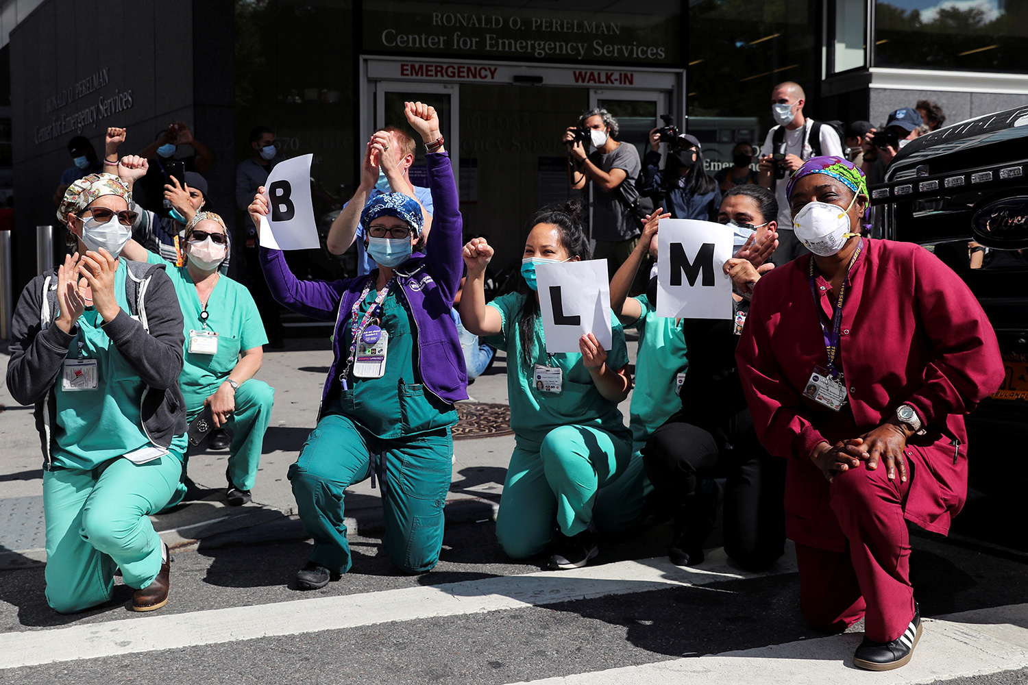 The photo shows a number of health workers taking a knee in protest.