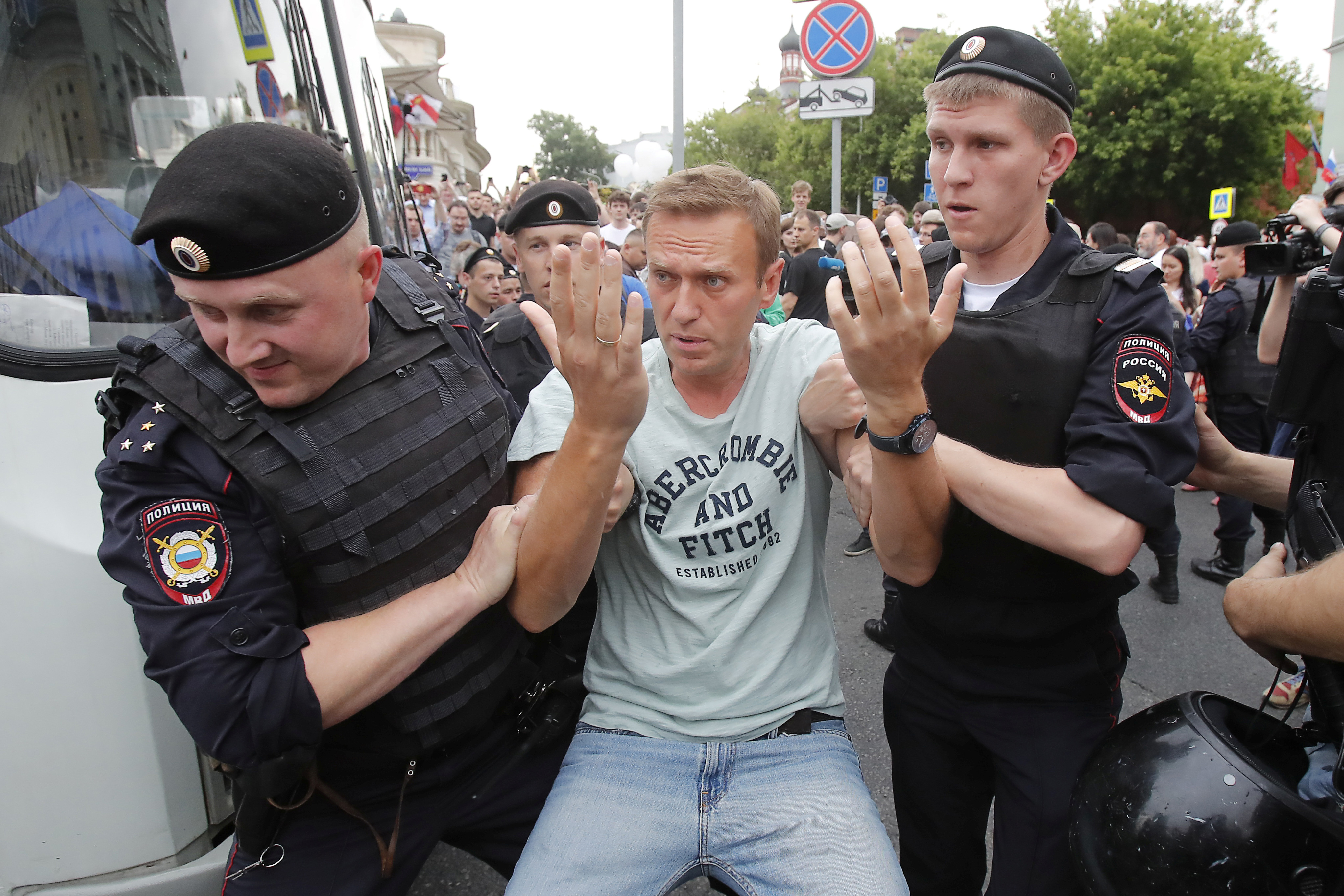 The photo shows two policemen dragging Navalny away as he holds up his hands.