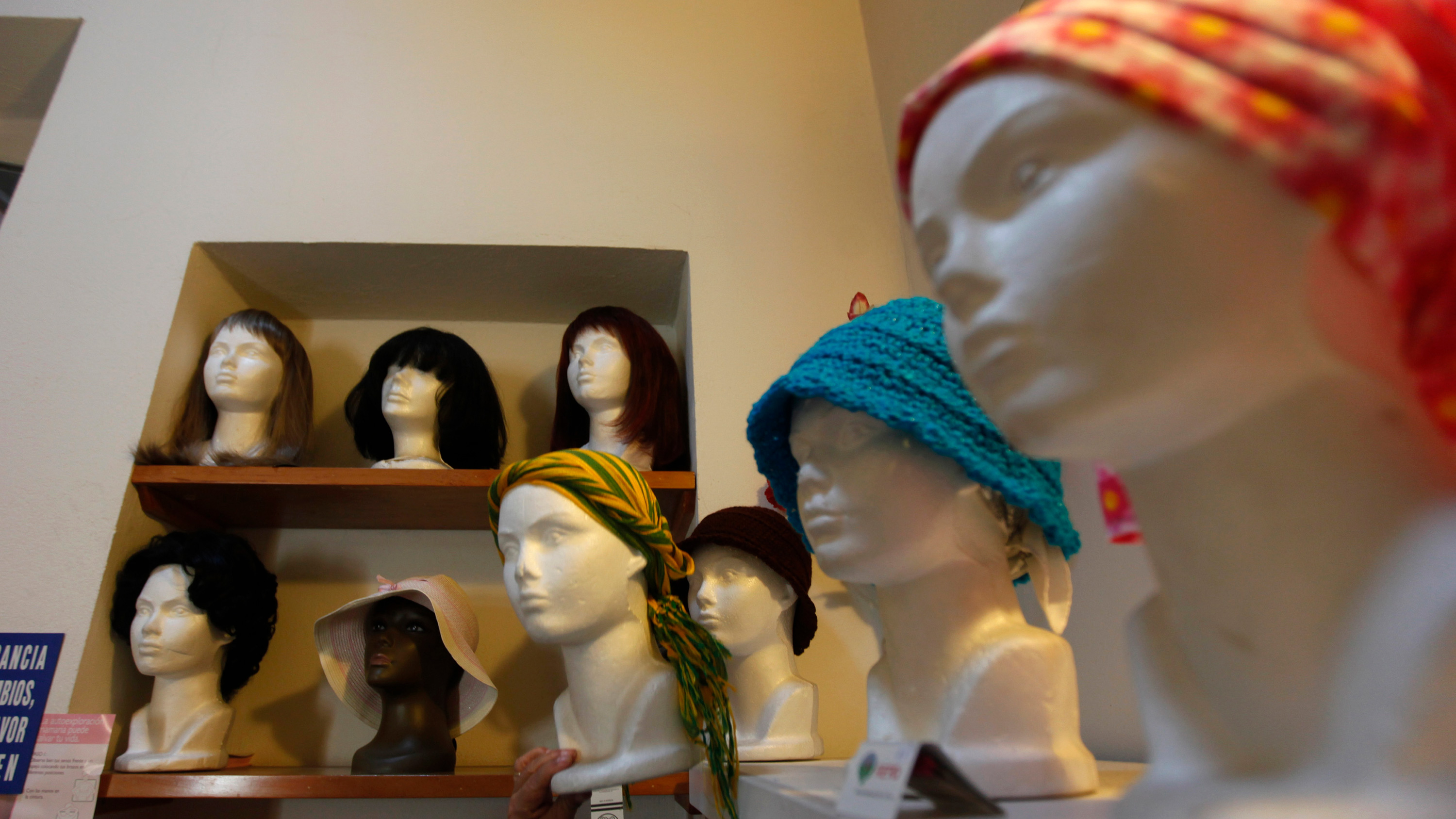 The photo shows a room with mannequin heads and wigs.