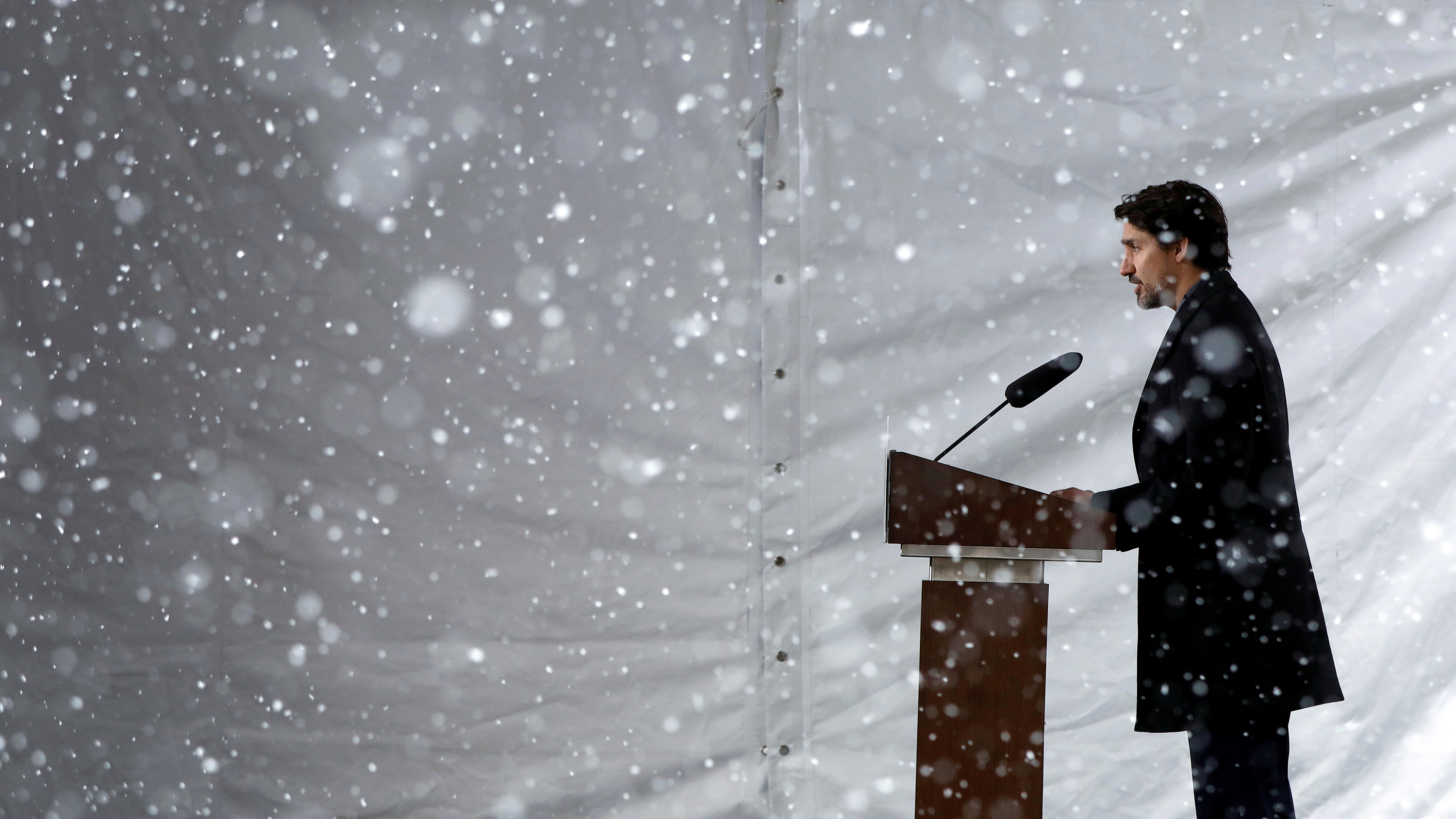 The photo shows the prime minister from the side standing at a podium while a driving snowstorm can be seen in the photo.