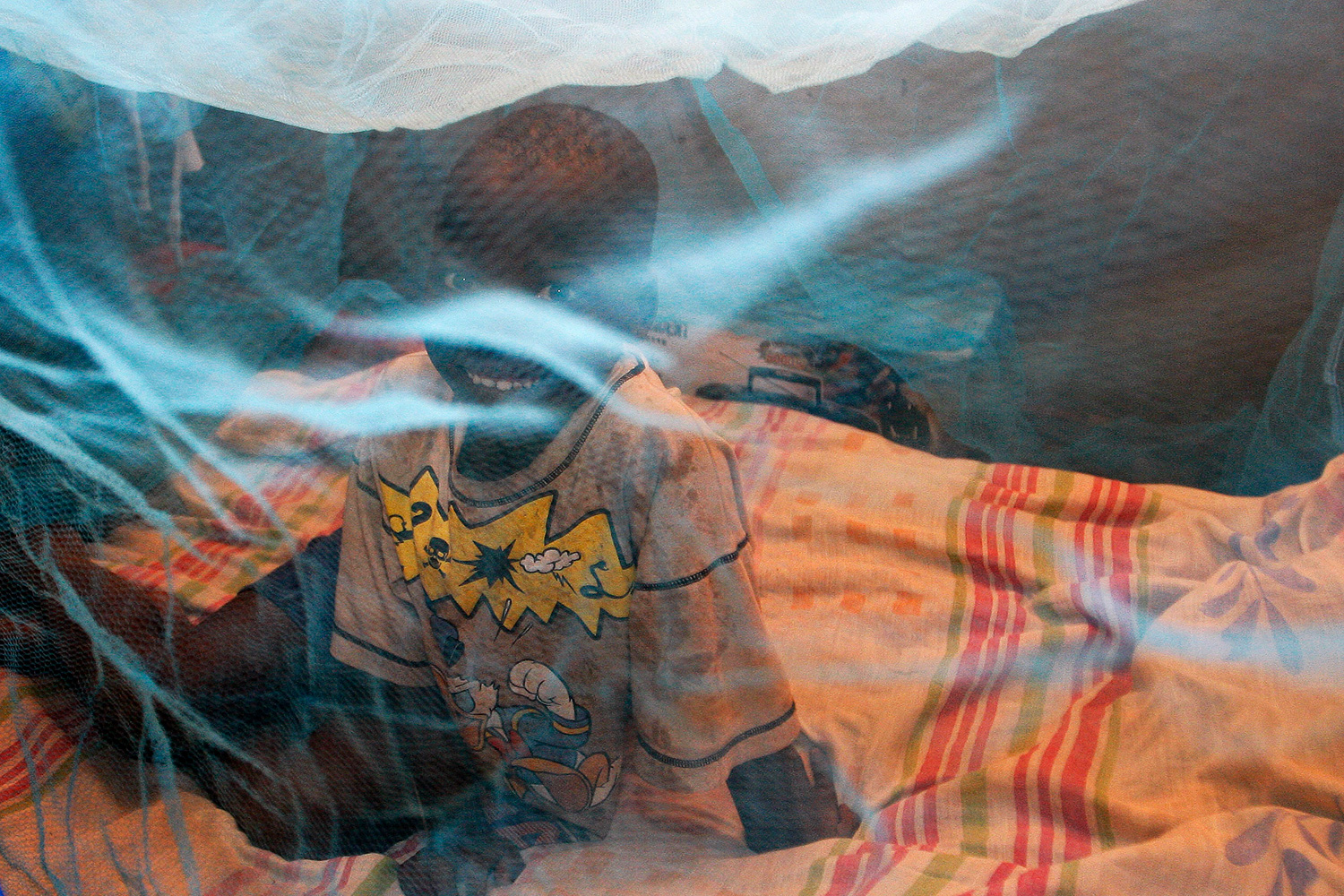 The photo shows the boy smiling through the blue-colored net.
