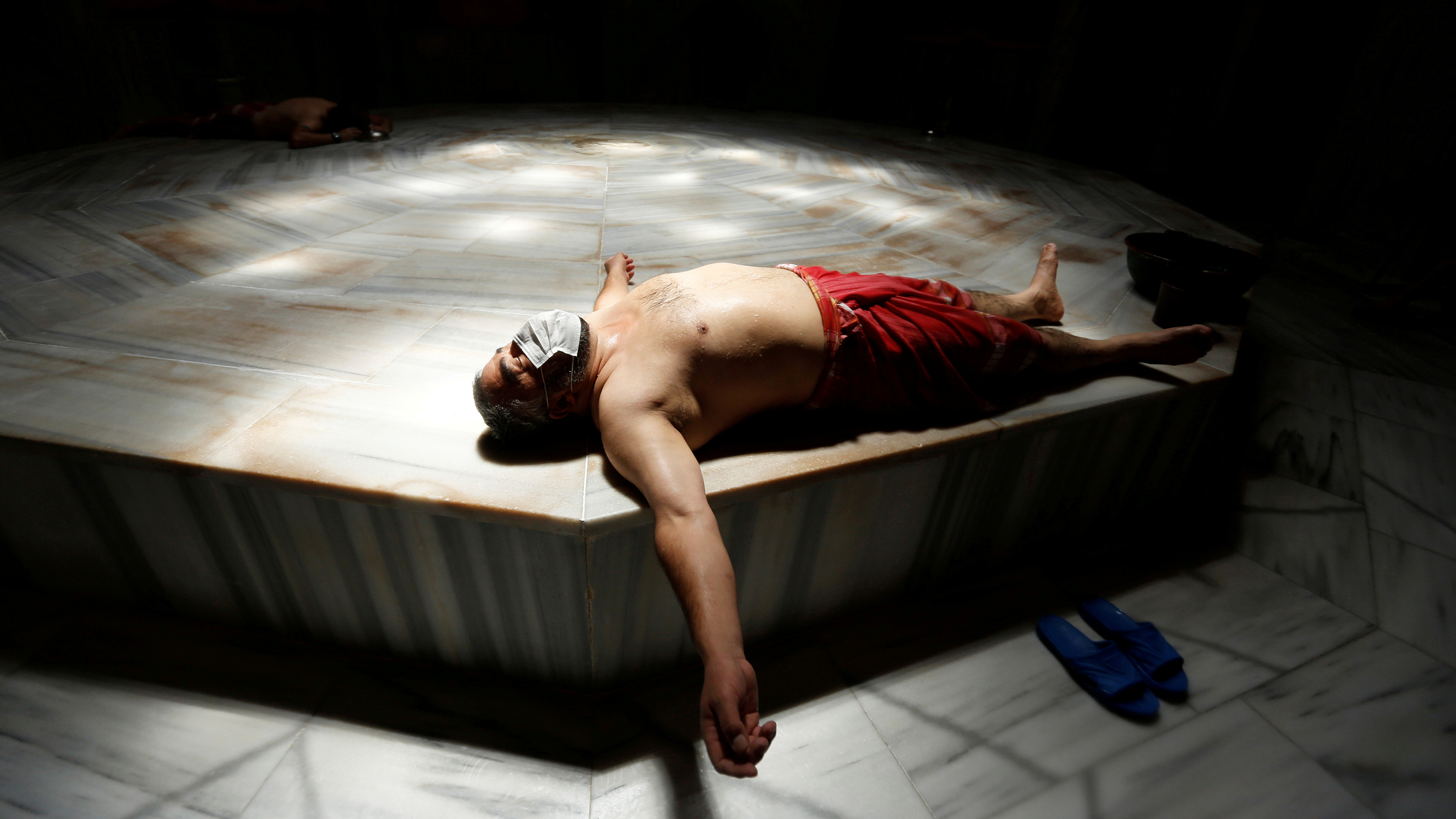 The photo shows the man lying on his back wearing a mask.
