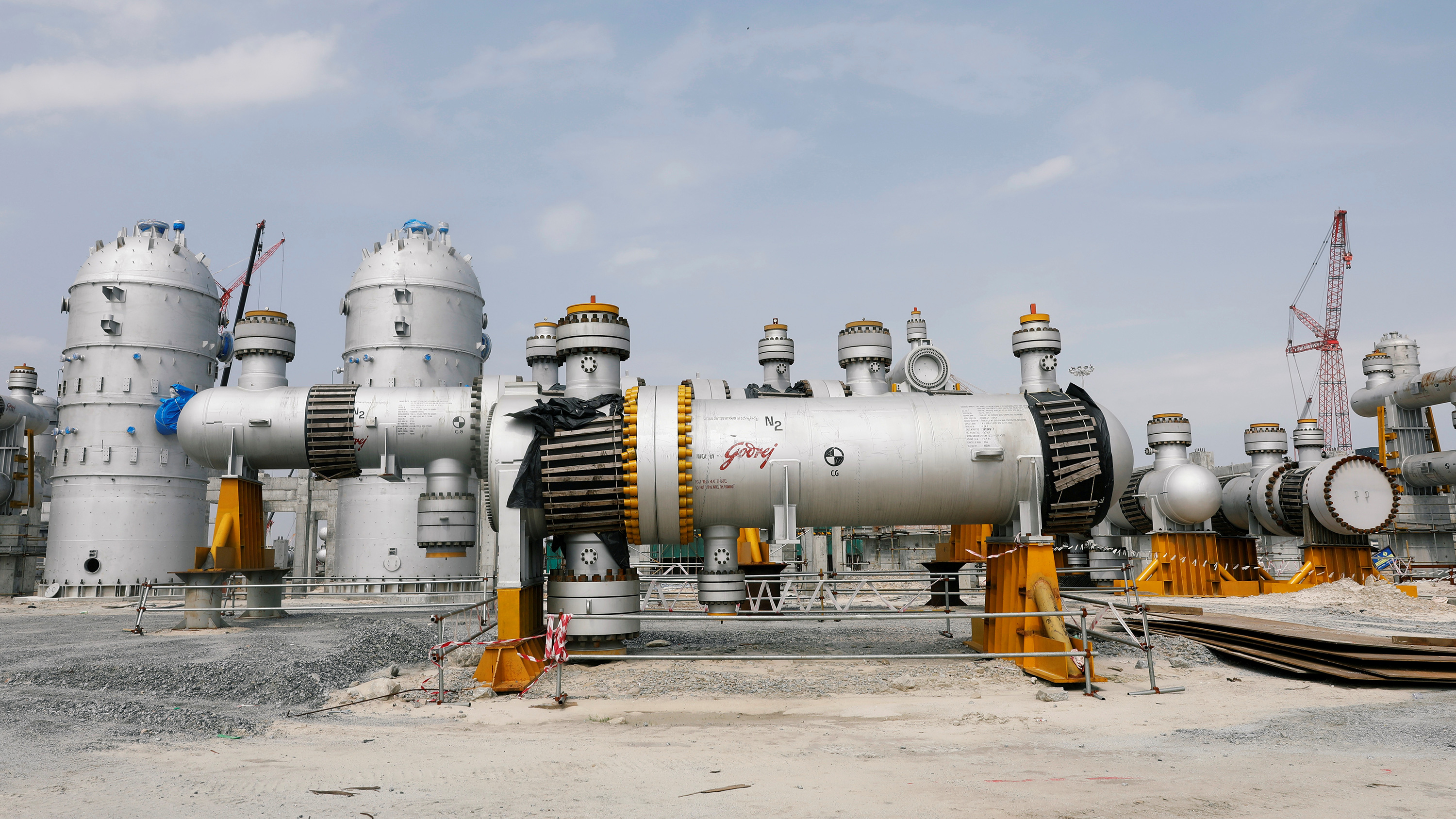 Image is of a major refinery with massive tanks and industrial equipment.