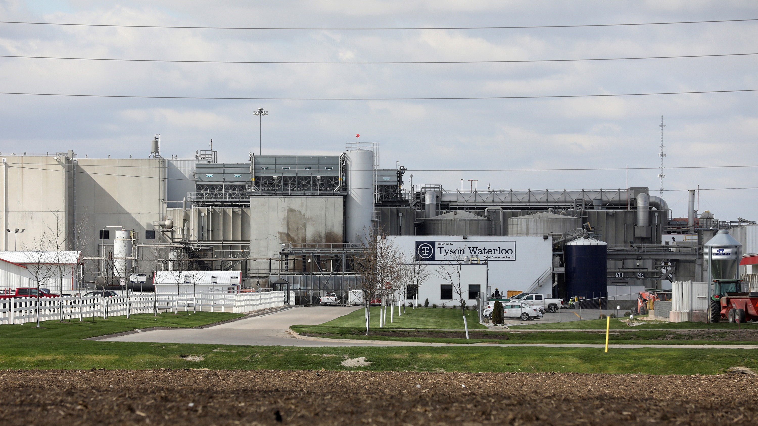 The photo shows the shuttered plant from behind a fence at a distance.