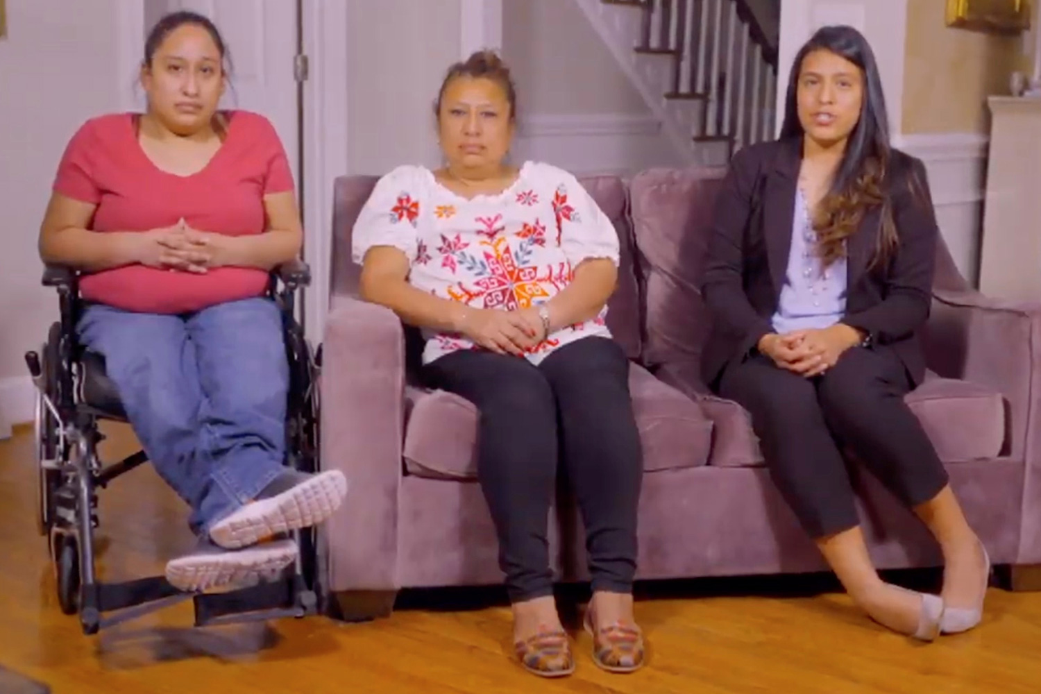 The photo shows the woman in her living room with her two daughters.