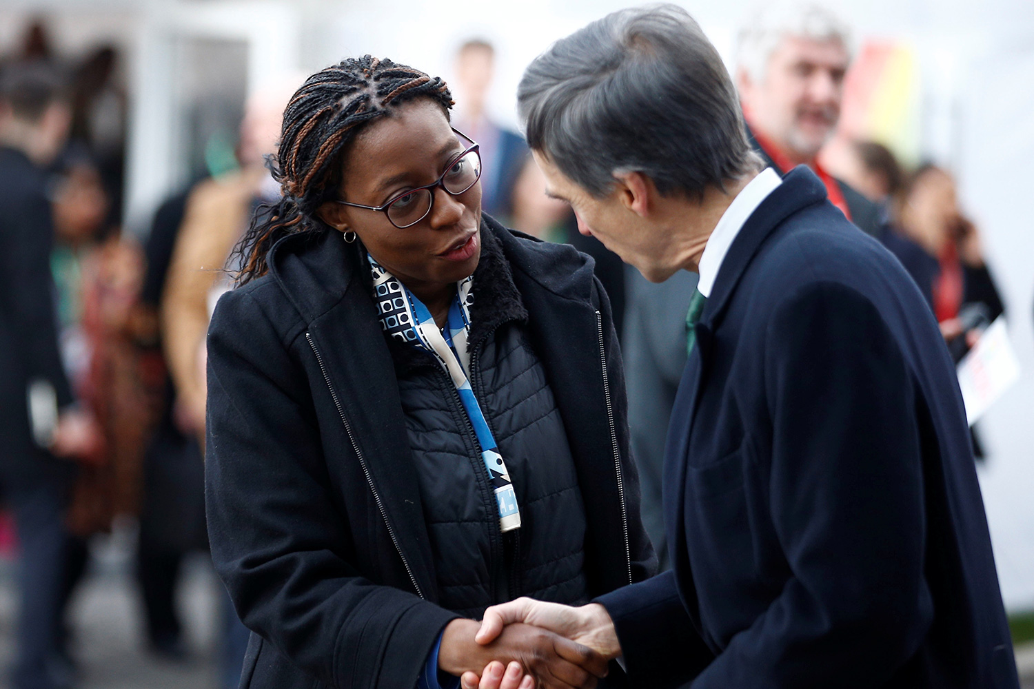 The photo shows Songwe and another delegate shaking hands.