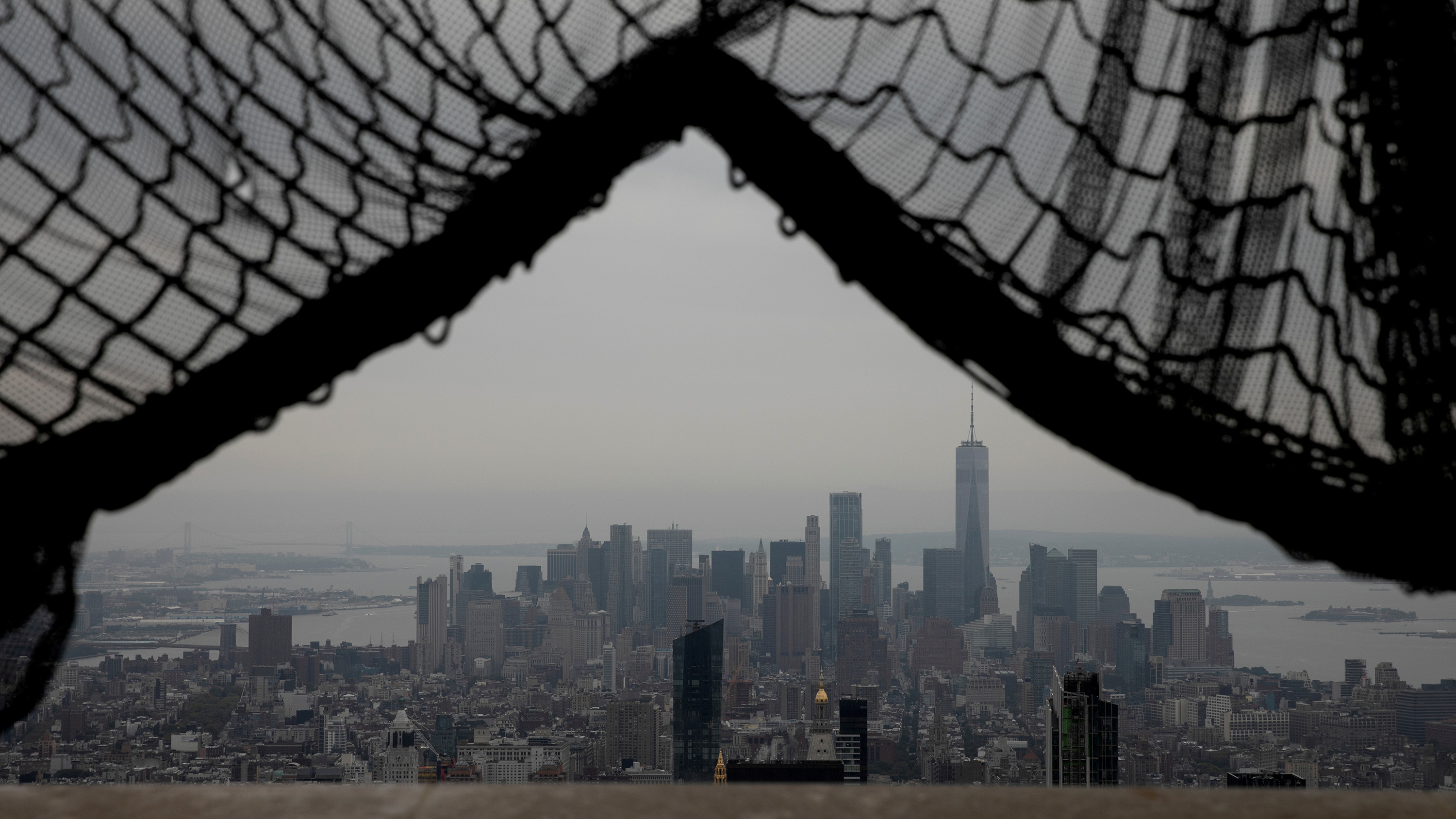 Picture shows the New York skyline seen from behind safety netting in an open construction atop a skyscraper looking across.