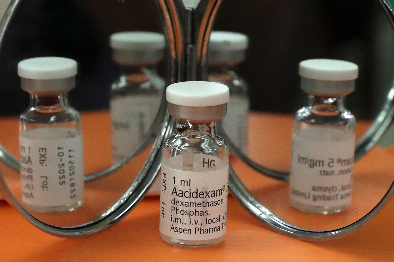The photo shows a vial of the drug in front of a fancy mirror, appearing as several vials in the reflection.