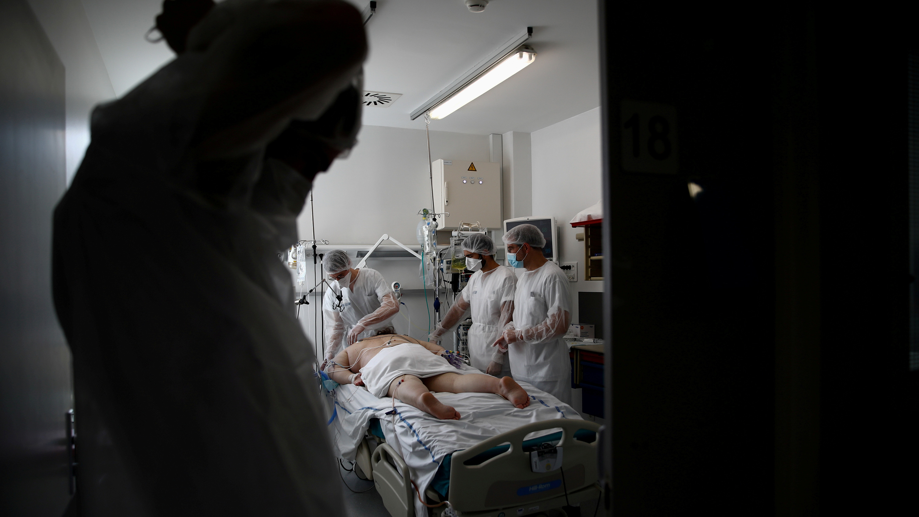 The photo shows a team of medical workers attending to the patient.