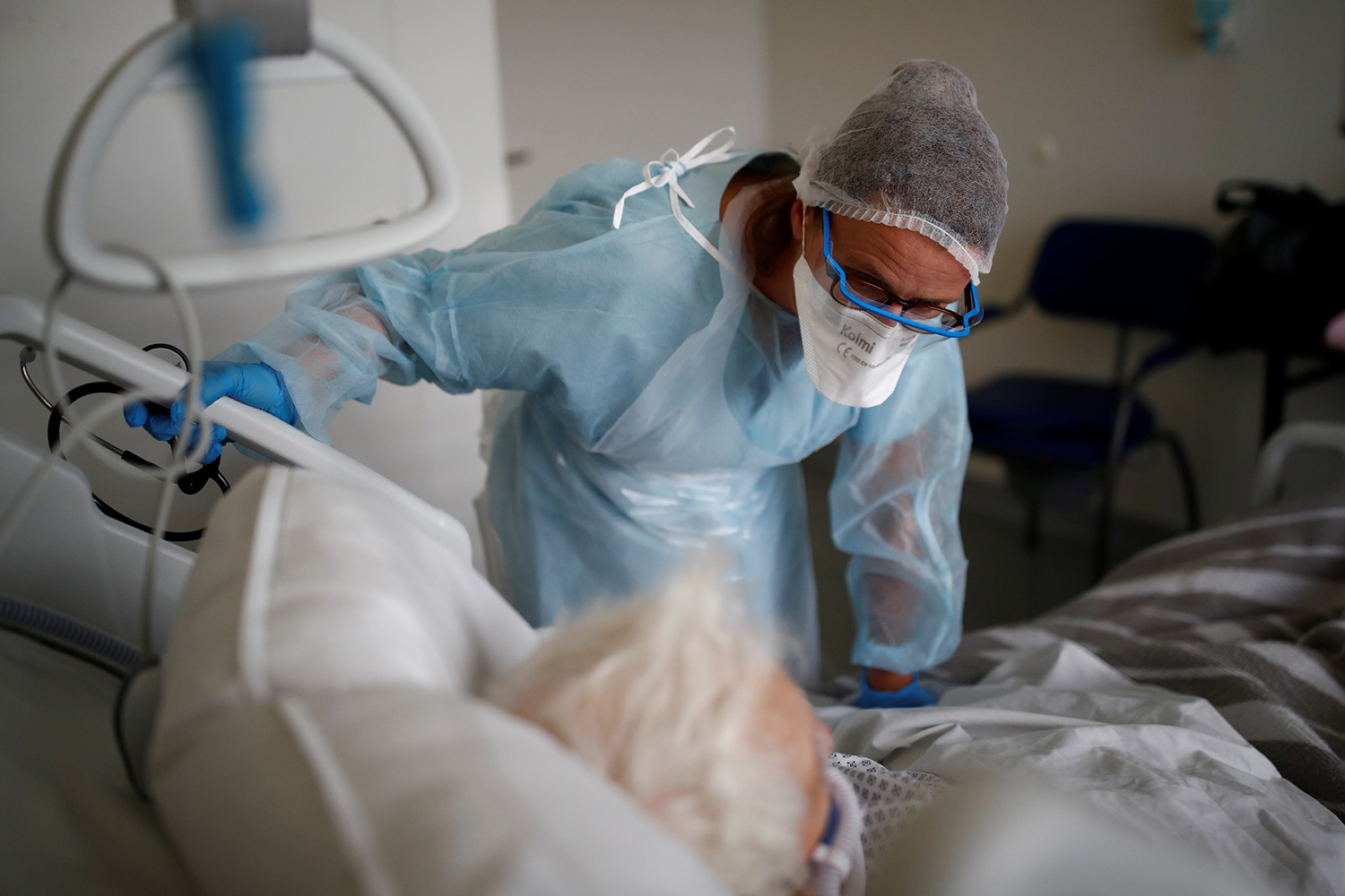 The photo shows the doctor bending over the patient's bed.