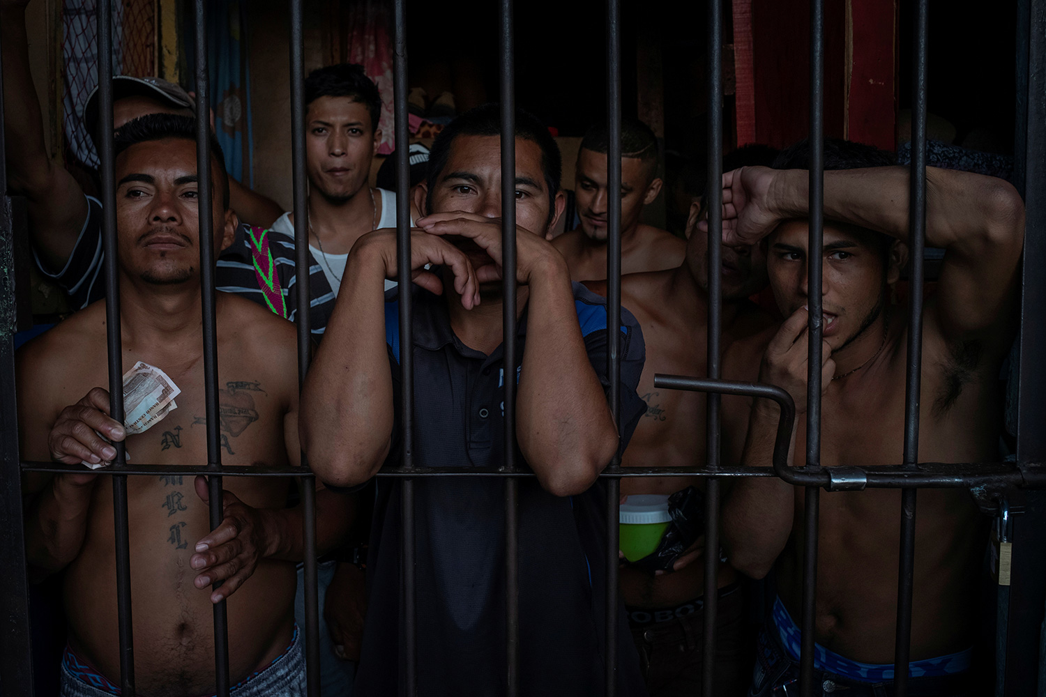 The photo shows a crowded cell of men looking out of their prison cell.