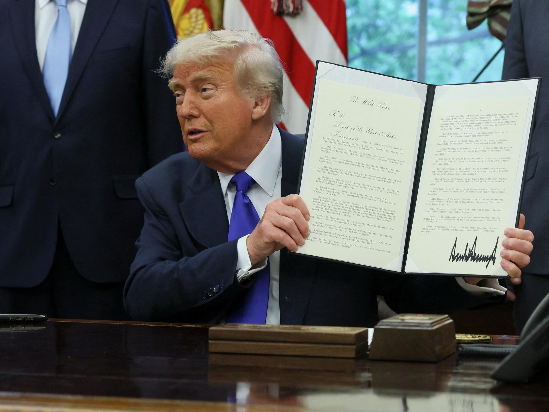 U.S. President Donald Trump shows a signed document as he signs executive orders and proclamations in the Oval Office at the White House, in Washington, D.C., U.S., May 5, 2025.