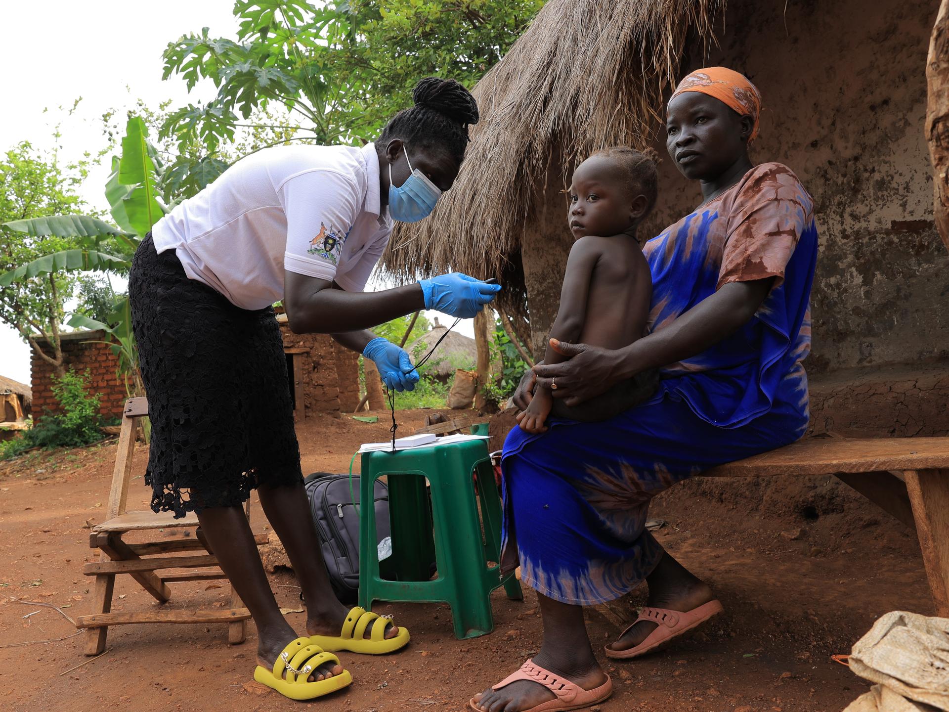 In Uganda’s Bidibidi refugee settlement, a Village Health Team member conducts an in-home health visit to a refugee mother and child. 