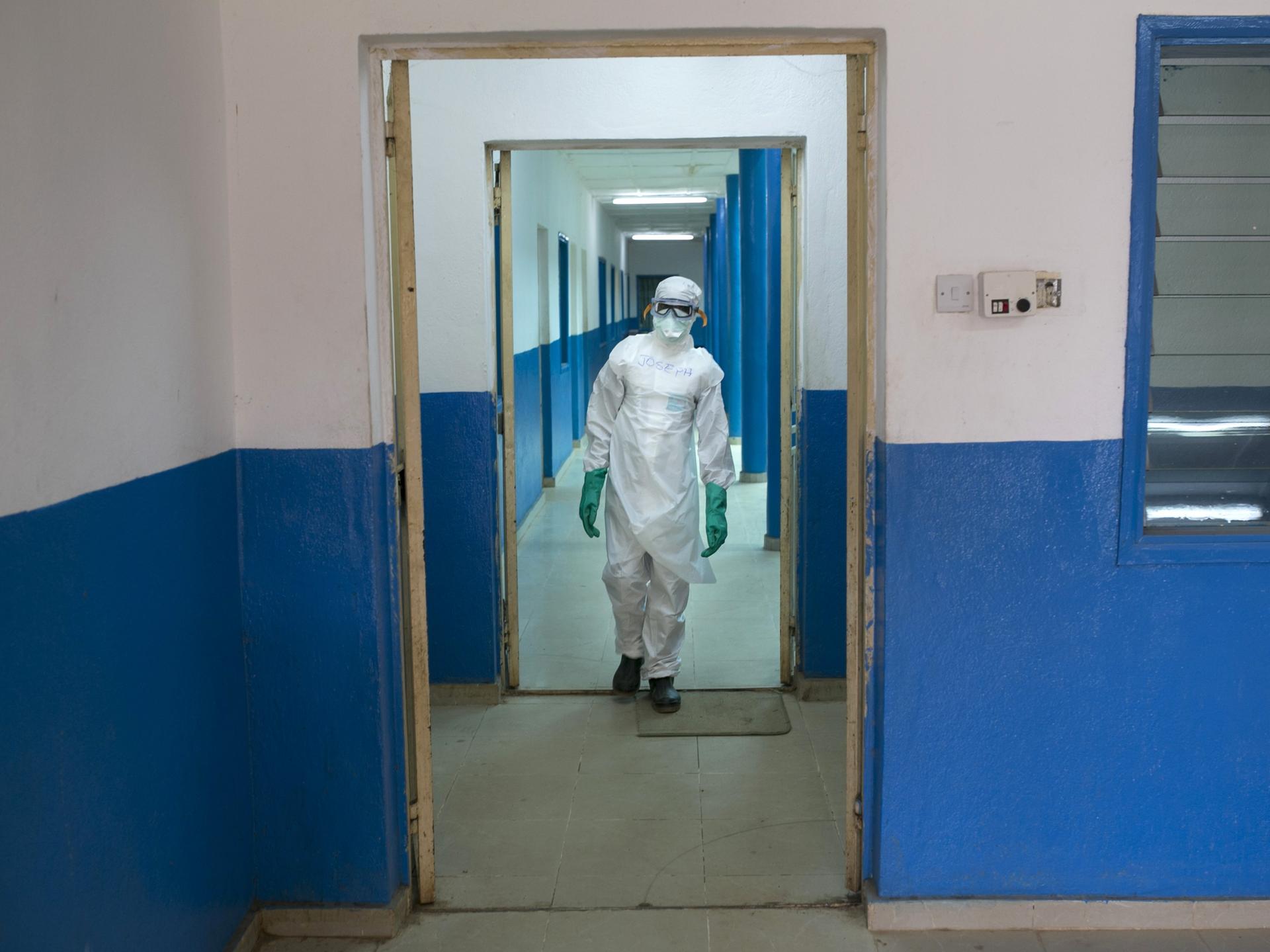 A health worker in protective gear walks inside a Red Cross facility in the town of Koidu, in Sierra Leone, on December 19, 2014.