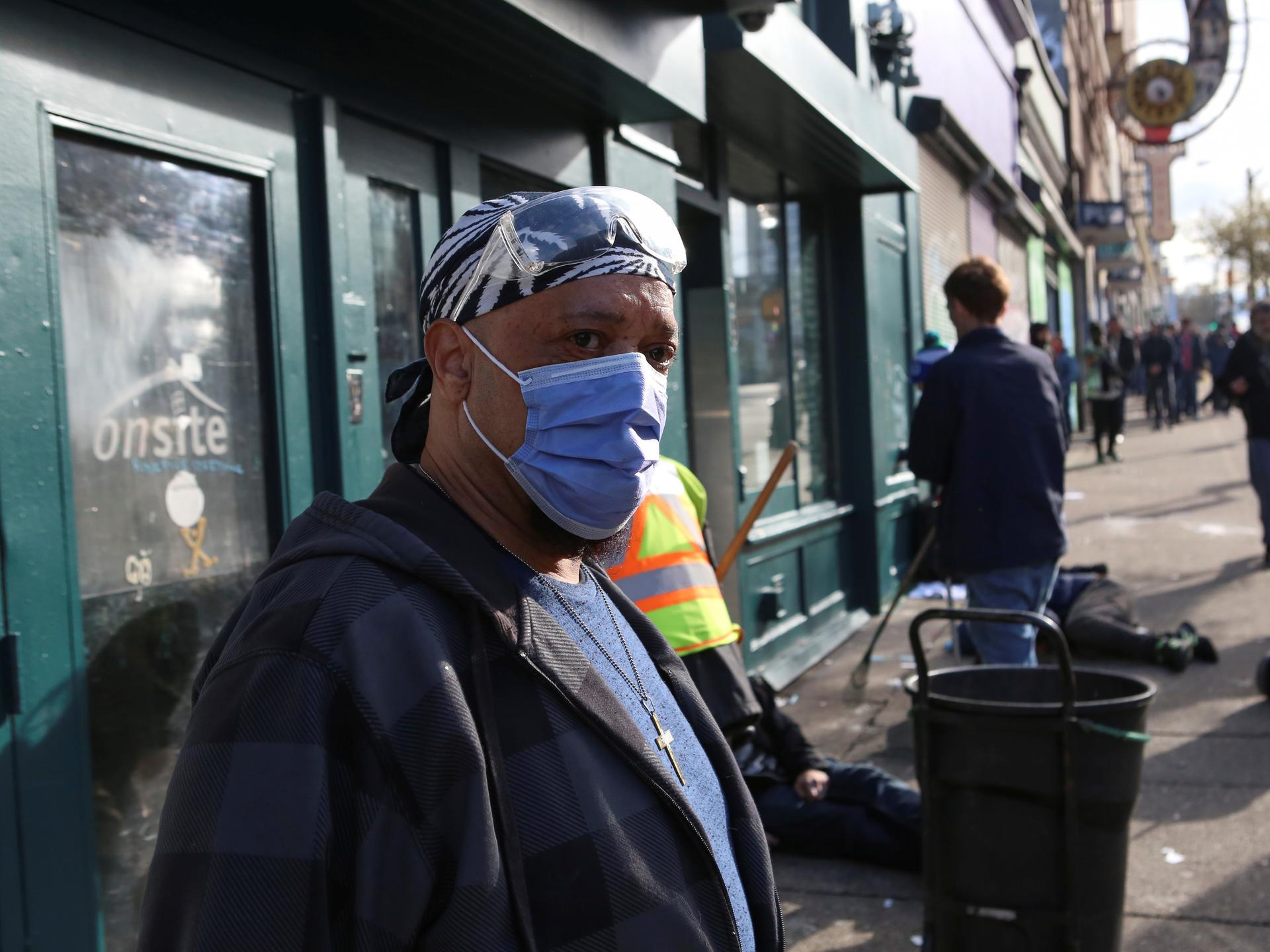 An InSite staff member directs drug users outside the supervised injection site on Hastings Street, in Vancouver, British Columbia, Canada, on March 25, 2020. 