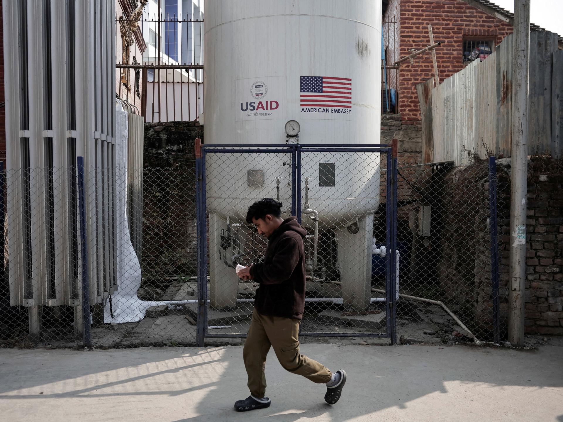 A man walks past the liquid oxygen storage tank installed at Bir Hospital by the United States Agency for International Development, in Kathmandu, Nepal, on February 9, 2025.