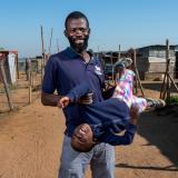 A man is pictured with his young son outside his home in Pretoria, South Africa.