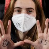 Climate activist Adelaide Charlier holds up her palms, which show a sketch of an eye and a 1.5