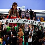 People gather around "Little Amal," a giant puppet of a young Syrian refugee girl at COP26