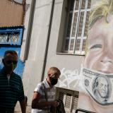 People walk past a work by Greek visual artist Hambas in Athens, Greece, on October 27, 2020.