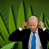 U.S. President Joe Biden puts on headphones to listen to speeches during the "Action on Forests and Land Use" event.