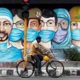 A man rides his bicycle past street art during the coronavirus disease outbreak in New Delhi, India, on July 17, 2020.