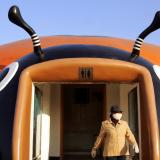 A bathroom attendant emerges from a beetle-shaped toilet at a park in Beijing, China, on November 17, 2004. 