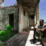A Grenadian man sits August 1, in the former prime minister's building which was bombed by American troops in the U.S. invasion on Grenada in 1983