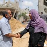 A Palestinian man and a Palestinian woman from shake hands after returning to their destroyed houses following an Israel-Hamas truce, in Beit Hanoun in the northern Gaza Strip on May 21, 2021. REUTERS/Mohammed Salem