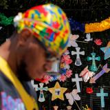 A man bows his head as he walks past a "Naming the Lost Memorials” site—memorials curated by artists and activists in memory of those who’ve died of COVID-19, at The Green-Wood Cemetery in Brooklyn, New York, on June 10, 2021.