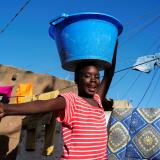 A girl carries a bucket with laundry on her head while heading home as the spread of the coronavirus disease continues, in Yoff neighbourhood, Dakar, Senegal on January 26, 2021