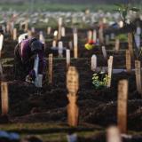 A woman mourns at the grave of her husband who passed away due to COVID-19, at a burial area provided by the government for COVID-19 victims as the country reports a record daily number of COVID-19 de