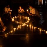 Activists sit next to candles laid out in the shape of an AIDS ribbon, commemorating World Aids Day in Jakarta, Indonesia, on December 1, 2021. 