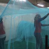 Employees at a bed net factory in Tanzania inspect nets for holes