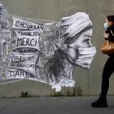 A woman walks past street art thanking frontline workers in Paris, France.