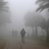 People walk in a park amid dense fog and smog in Lahore, Pakistan, on December 21, 2019