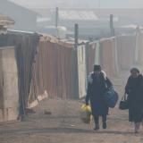 Women walk with their belongings amid smog in Sukhbaatar district of Ulaanbaatar, Mongolia, on January 31, 2019.
