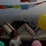 A girl holding a balloon looks towards the sky during a smoggy day as the government has ordered schools to close for four days after the air pollution climbed to hazardous levels, forcing millions of students to stay home across the country,